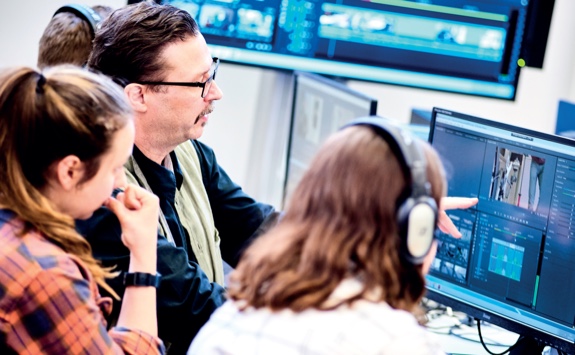 Students editing some media on a computer